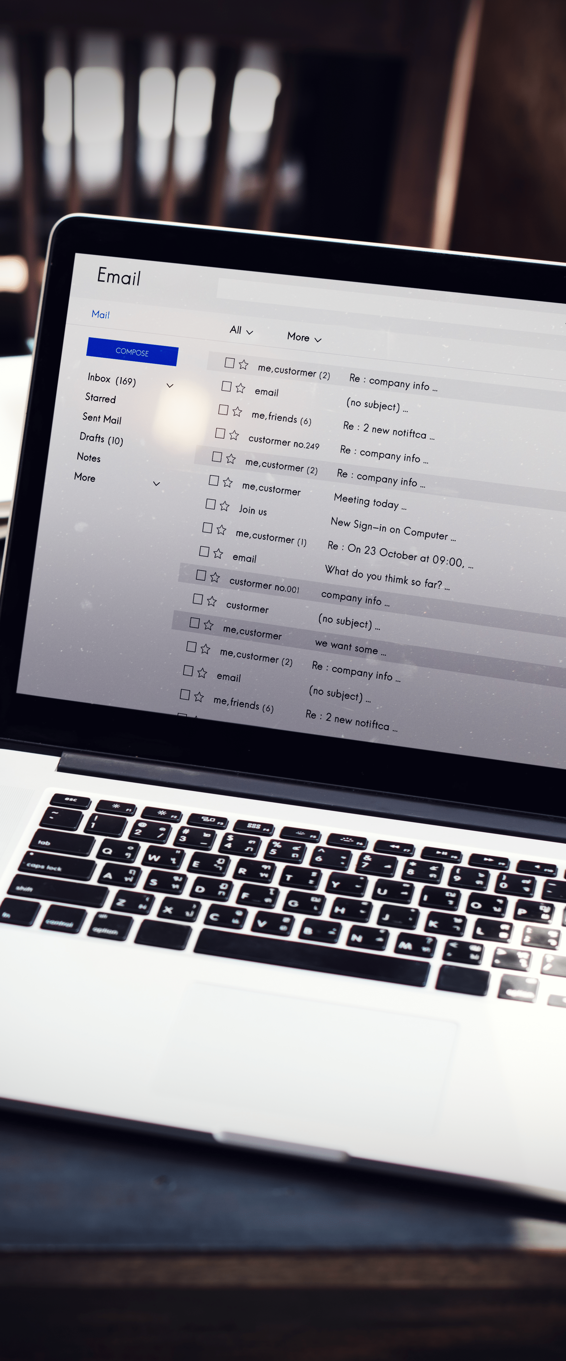 A laptop on a desk displaying an open email inbox with various messages from Professional Email Services with SmartHost.