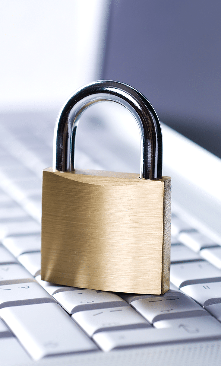 A brass padlock placed on a white computer keyboard in front of a partially visible monitor symbolizes digital security, much like using a free SSL certificate generator to protect your online data.