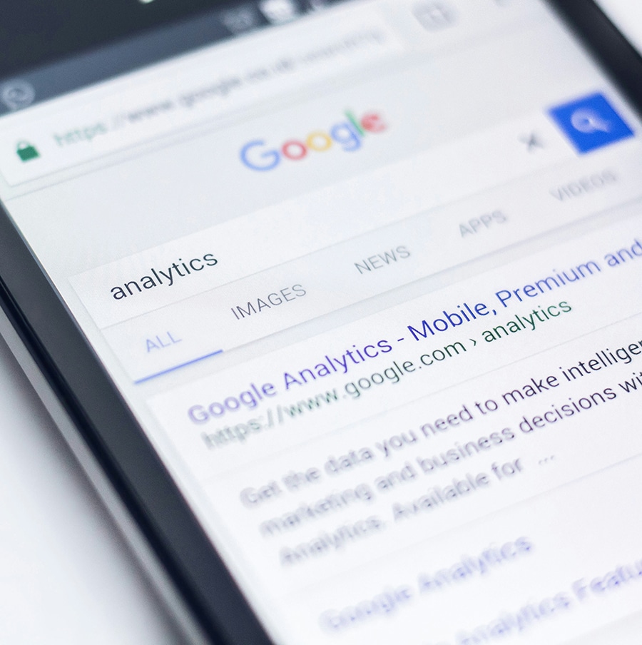 A smartphone screen displays a Google search results page for "analytics," including a link to Google Analytics.