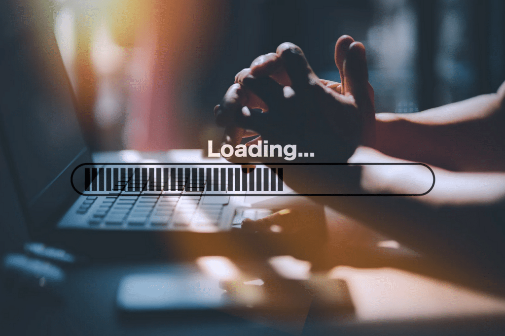 A person sits at a laptop with hands clasped, while a digital loading bar with the word "Loading..." is displayed over the image.